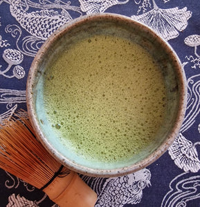 Frothy bowl of matcha gaba green tea blended with calming organic reishi powder