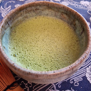 Frothy bowl of matcha gaba green tea blended with calming organic reishi powder